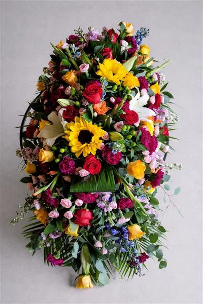 Bright Sunflower & Rose Casket Spray — Bright and colourful mix of seasonal flowers available at the time of ordering. Please allow 2 worki