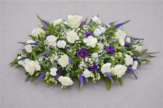 Purple & White Seasonal Casket Spray — A mix of seasonal blooms in whites and purples. Please allow 2 working days notice when ordering thi