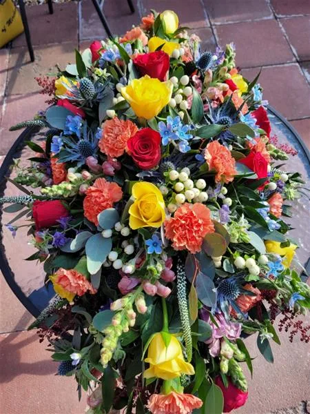 Seasonal Rainbow Casket Spray — Bright and colourful rainbow mix of seasonal flowers available at the time of ordering. Please allow