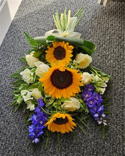 Golden Sunlight & White Serenity Sunflower Tied Sheaf — Delicate avalanche roses and vivid sunflowers unite in this elegant sympathy sheaf, embracing warmth