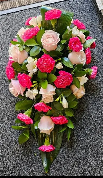 Rose & Carnation Blush Elegance Sympathy Oasis Spray — Soft Sweet Avalanche Roses take center stage in this heartfelt arrangement, their pale pink petals w