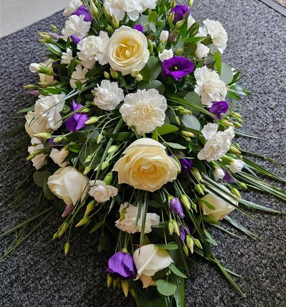 Tranquil Whites and Purples Sympathy Oasis Spray — Soft white roses and spray carnations form the heart of this tranquil arrangement, offering timeless