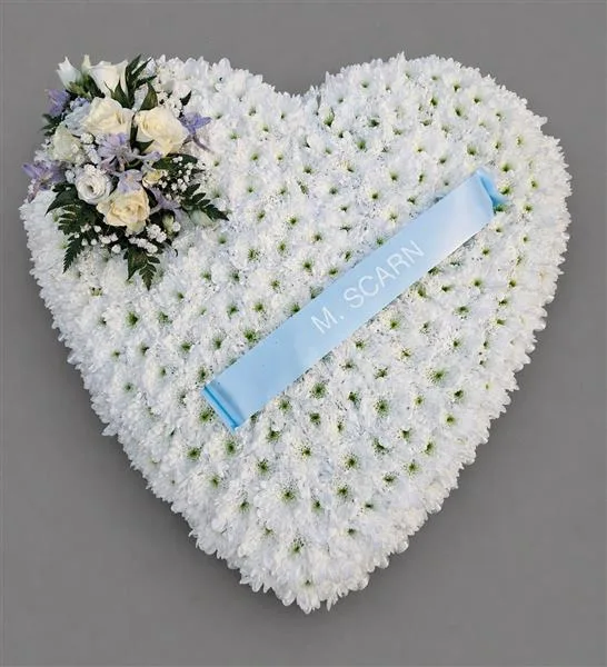 Based Solid Heart — Based heart arrangement in pale blue against a white chrysanthemum base, edged with ribbon and match