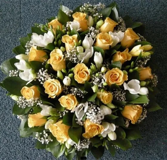 Lemon & White Rose Posy Arrangement — This arrangement consists of roses, freesia, gypsophila and foliage, finished with a complementary r