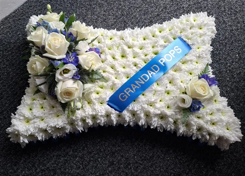 Blue & White Pillow — Based pillow arrangement in shades of blue against a white chrysanthemum base, edged with ribbon or 