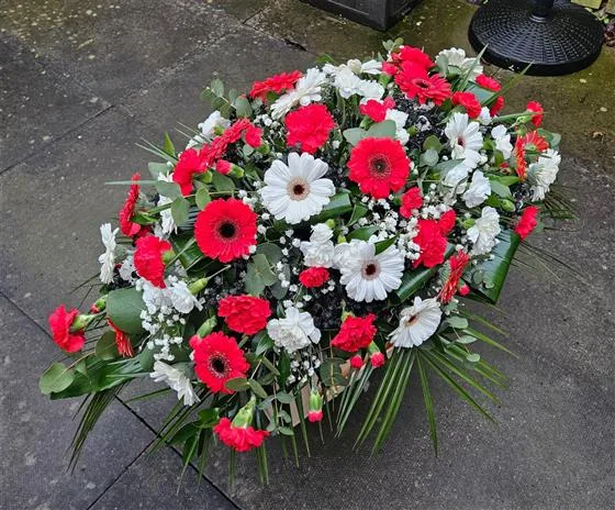 SUFC Casket Spray — A casket spray featuring red roses and mini gerbera daisies in red and white creates a striking and 