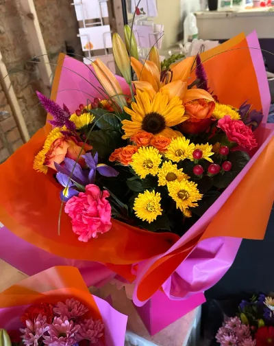 The Sunburst — bold, sunny bouquet bursting with orange, yellow and hot pink, hand-tied.