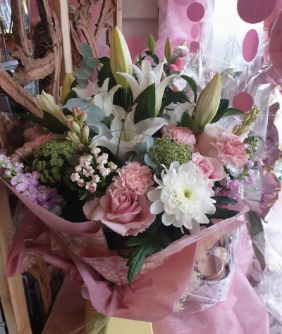 The Pearl — White lilies, pink roses and chrysanthemums with fresh greenery, wrapped in pale pink.