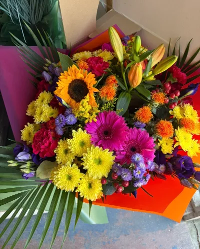 The Summer — Sunflowers, gerberas, lilies and purple statice in a vibrant summer mix.