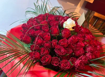 The Red Romance — A lavish bouquet of red roses, finished with greenery.