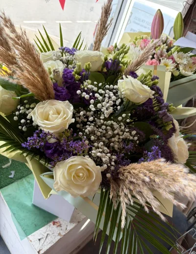The Boho — White roses, pampas grass, purple statice and gypsophila in a boho-style bouquet.
