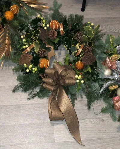 The Gilded — Fresh foliage with dried oranges, golden berries and gold accents, finished with a gold bow.
