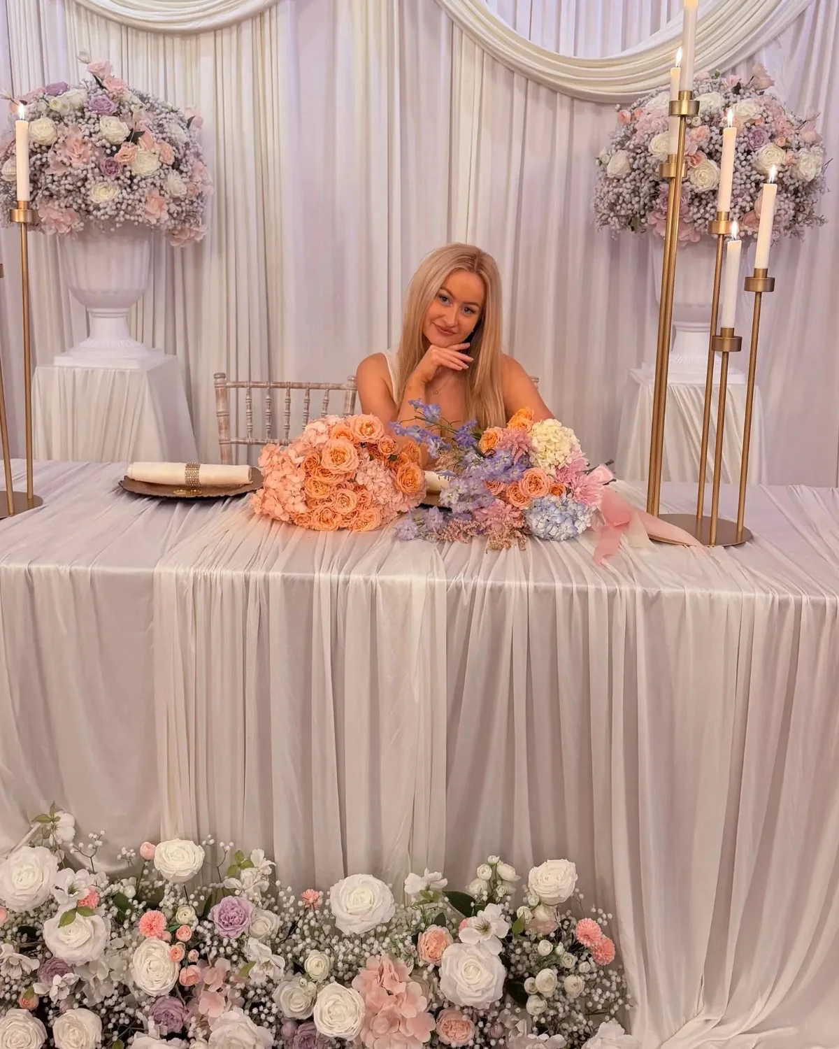 Kerrin, the florist behind Maison Bloom, at a wedding top table she styled
